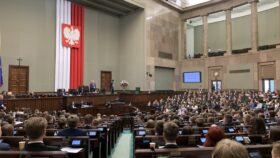 Widok na salę obraz Sejmu RP. W ławach zasiadają dzieci i młodzież uczestniczące w sesji Sejmu Dzieci i Młodzieży.