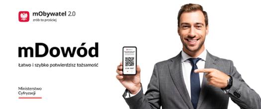 Młody mężczyzna w garniturze trzyma w dłoni telefon z kodem QR